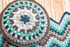 two crocheted pillows sitting on top of a wooden floor