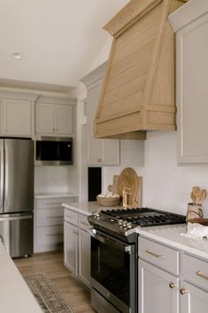 a kitchen with white cabinets and stainless steel appliances