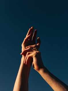 two hands reaching up into the sky