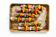 skewered meat and vegetable kebabs on a baking tray with toothpicks