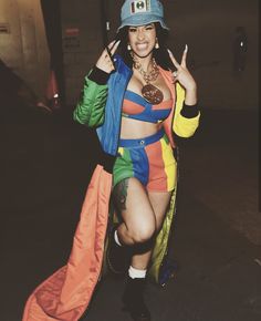 a woman in a colorful outfit posing for the camera