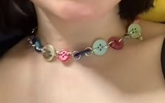 a woman wearing a necklace with buttons on it