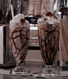 two glasses filled with ice cream and chocolate milkshakes