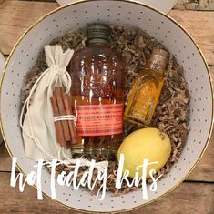 a white bowl filled with lots of different types of liquor and cinnamons next to a lemon