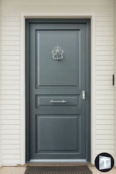 the front door is painted gray and has a welcome mat on it that says,