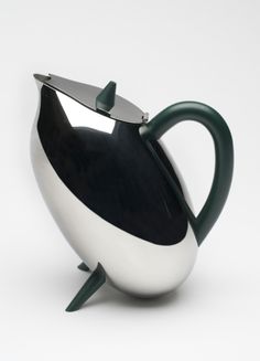 a black and white teapot with a green handle on it's side, sitting in front of a white background