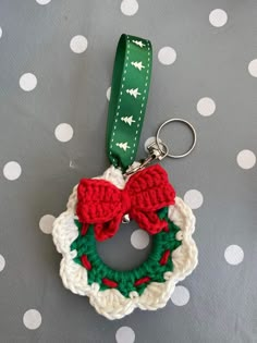 a crocheted christmas wreath ornament hanging on a polka dot tablecloth