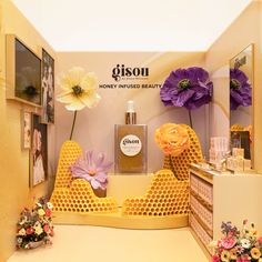 a store display with flowers and honeycombs on the shelves, as well as perfume bottles