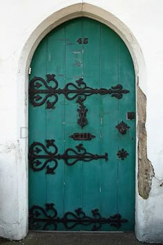 a green door with an iron cross on it