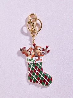 Deck your bag with Chip 'N Dale cheer! The Disney Chip 'N Dale Stocking 2D Bag Charm features our favorite chipmunks cozied up in a Christmas stocking, bringing festive fun to your purse. Easily clip it on to spread holiday joy wherever you go. Enhance your bag with our stylish Bag Charms crafted from premium materials. Please consider your bag's material to prevent potential surface impact. Enjoy accessorizing without worry! This is an officially licensed Disney product. Chip And Dale Christmas, Packing Aesthetic, Disney Baubles, Disney Baublebar, 2d Bags, Keychain Disney, 2024 List, Backpack Charms, Disney Chip