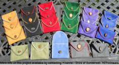 several different colored purses sitting on top of a bench