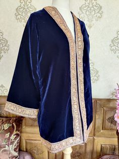 Velvet Kimono, Blue Kashmiri Robe With Gold Tilla Embroidery, Luxury Kimono Robe A luxurious Kashmiri Velvet Robe with Tilla Embroidery, The Fabric Used in This robe Is velvet 9900, One of the finest in the Market and the Golden embroidery is Done By the Lustrous Metallic Thread Known as Tilla,  The robe is of One size as It has a kimono Look and The arms are of bell shape though if you want we can also customise it into jacket fit  DETAILS:  Embroidery: Tilla Work  Length: 32(125 cm) Lining: Fu Elegant Embroidered Kimono For Eid, Bohemian Kaftan With Embroidered Border, Bohemian Kaftan With Embroidered Border And Traditional Drape, Elegant Blue Kaftan With Dupatta, Traditional Blue Kaftan With Dupatta, Elegant Festive Kaftan With Embroidered Border, Ceremonial Embroidered Elegant Kimono, Designer Long Sleeve Kaftan With Embroidered Border, Traditional Blue Long Sleeve Kimono