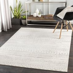 a living room with a white rug and black chair