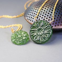 Unique, carved gemstone medallions star in these  gold filled necklaces. Made with delicate woven chain these necklaces feature unique, carved with beautiful floral designs, coin shaped, green Antigorite serpentine. Four available, two with  19mm medallions (options A and B) and two with 25mm medallions  (Option C and D).  Each one of these necklaces looks stylish and elegant, each makes make a statement. These necklaces are to be purchased separately.  Completed with gold filled, lobster claw c Carved Yellow Gold Amulet Jewelry, Carved Yellow Gold Necklace, Carved Gold Round Pendant Jewelry, Gold Carved Round Pendant Necklace, Carved Yellow Gold Necklace For Gift, Carved Yellow Gold Necklace Perfect For Gift, Spiritual Carved Medallion Necklaces, Handmade Jade Necklace With Flower Pendant, Handmade Jade Flower Pendant Necklace