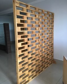 a room divider made out of wooden planks in the middle of a tiled floor