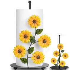 a white cake with yellow sunflowers painted on it and two black stand holders