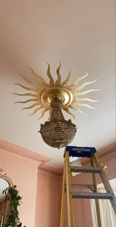 a light that is on top of a ladder in a room with pink walls and ceiling