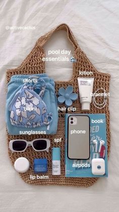 the contents of a purse laid out on top of a white sheet with blue flowers