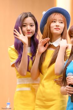 three girls in yellow dresses and hats are posing for the camera with their hands up