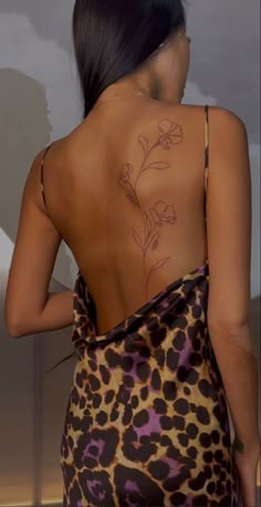 the back of a woman's body with tattoos on her upper and lower back