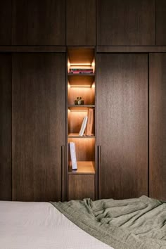 a bed with a white comforter and wooden cabinets