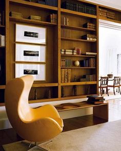 a living room filled with furniture and bookshelves next to a wall mounted tv