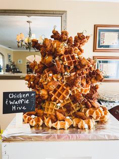 a stack of chicken and waffles sitting on top of a table next to a mirror