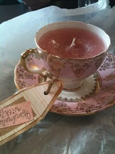 a pink tea cup with a saucer and spoon