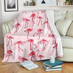 a pink flamingo blanket sitting on top of a wooden floor next to a couch