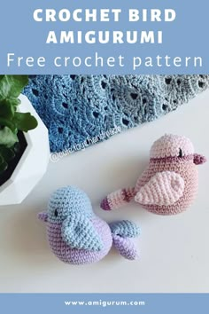 two crocheted birds sitting on top of a table next to a potted plant