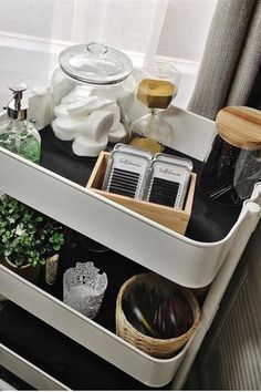 a white shelf filled with lots of items next to a window