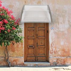 an old building with a potted plant next to it and a wooden door on the side