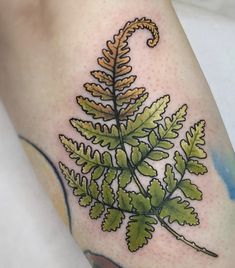 a green leaf tattoo on the leg