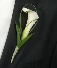 a white calla lily boutonniere on a black suit