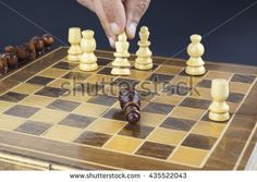 a man playing chess with his hand on the queen's board and pawns