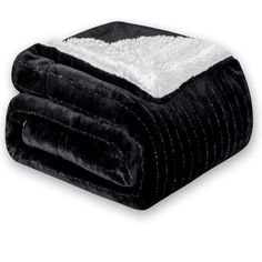 a black and white blanket is folded on top of each other, with a fuzzy edge