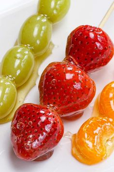 there are jelly fruits on the plate and one is green, orange, and red