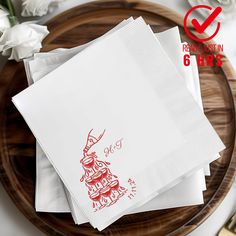 four napkins with red ink on them sitting on a wooden plate next to white flowers