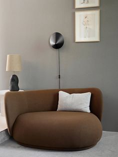 a brown couch sitting next to a lamp on top of a table