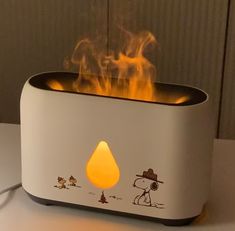 a white toaster sitting on top of a table with flames in the air next to it