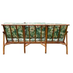 a wooden bench with floral upholstered fabric on it's back and arms