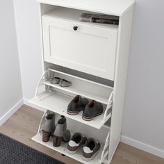 a white shoe rack with two pairs of shoes on top and one pair of slippers below