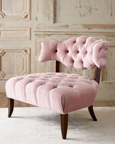 a pink chair sitting on top of a white rug