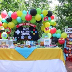 a table topped with balloons and other items for a children's first birthday party