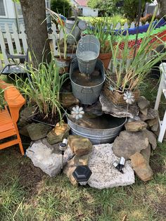 an outdoor fountain surrounded by rocks and plants