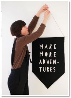 a woman hanging a black banner on the wall