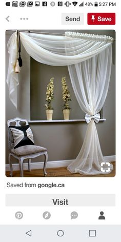 an image of a room with white curtains and flowers in vases on the window sill