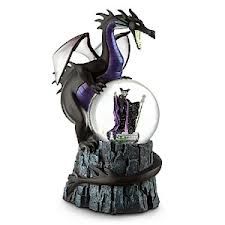 a snow globe with a black dragon in the middle and purple boots on it, sitting on top of a rock