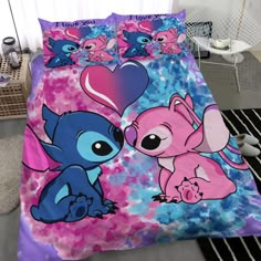 a bed with two cartoon characters on it and pink, blue, and purple sheets