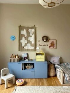 a child's bedroom with a blue dresser and bed